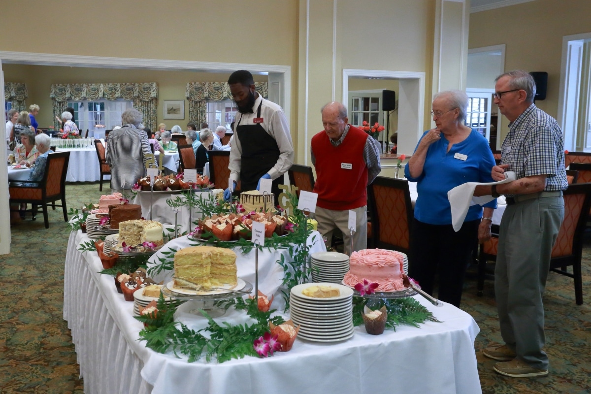 Redstone Village residents and employee selecting desserts at 15th anniversary celebration